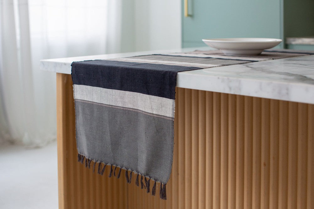 Grey color block table runner hanging off the end of a kitchen island