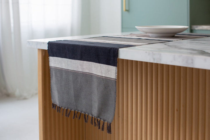 Grey color block table runner hanging off the end of a kitchen island