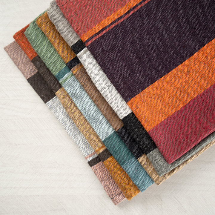 Close-up of stacked color block napkins showing the hand-spun cotton texture