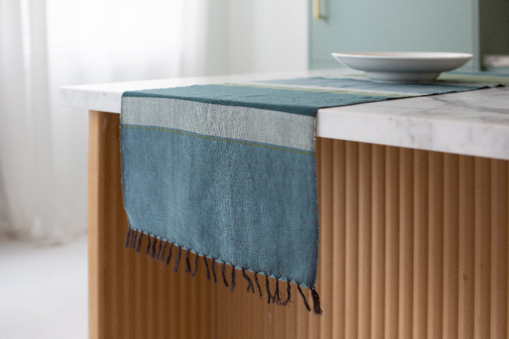 Steel blue color block table runner hanging off the end of a kitchen island