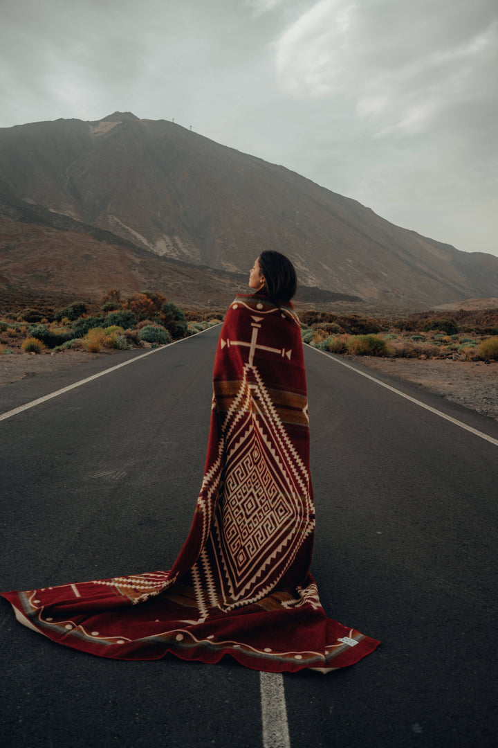 Handwoven Achuar Autumn blanket in warm rust with cream and olive accents.