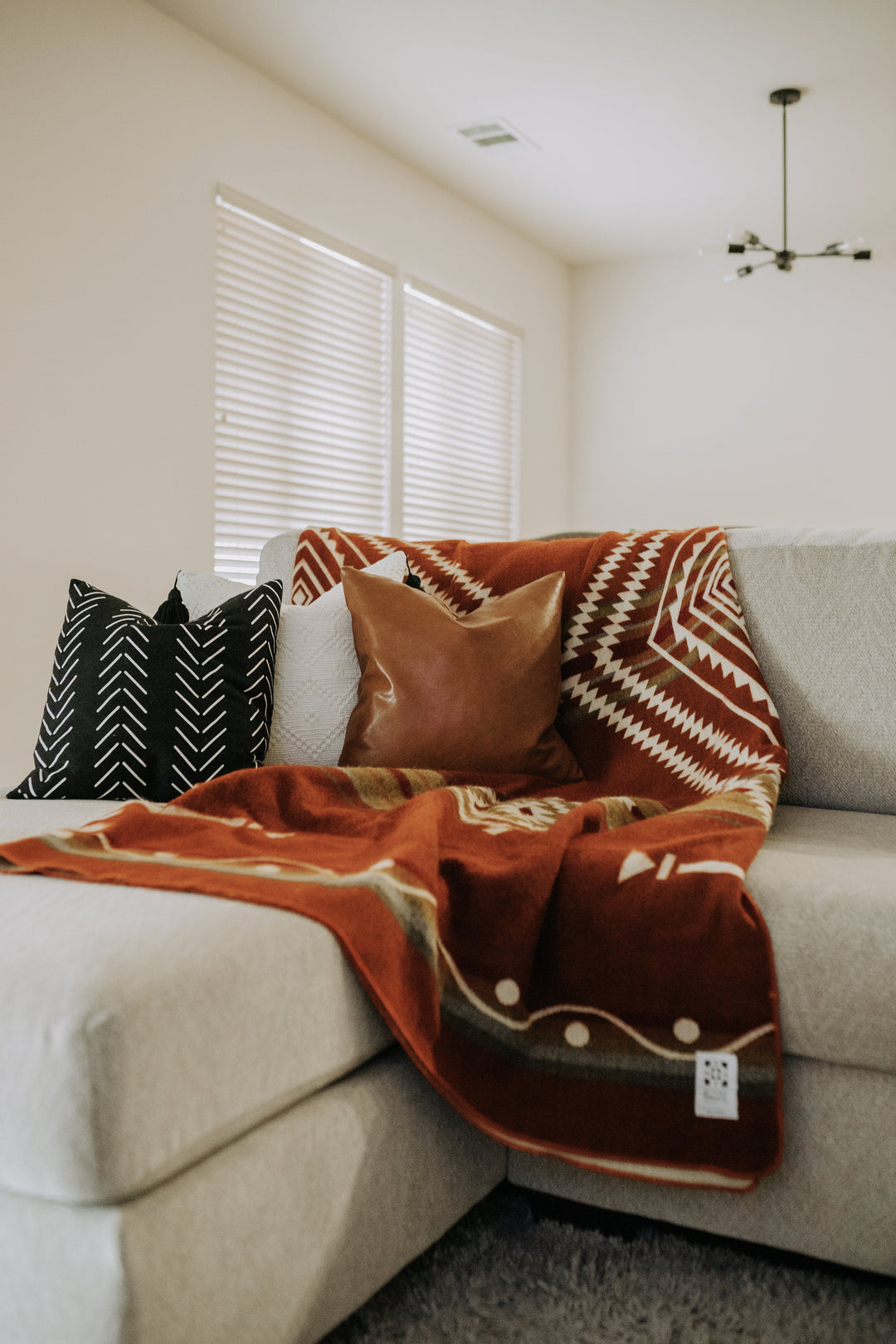 Achuar Autumn throw blanket in rust, cream, and olive - Andean geometric weave.