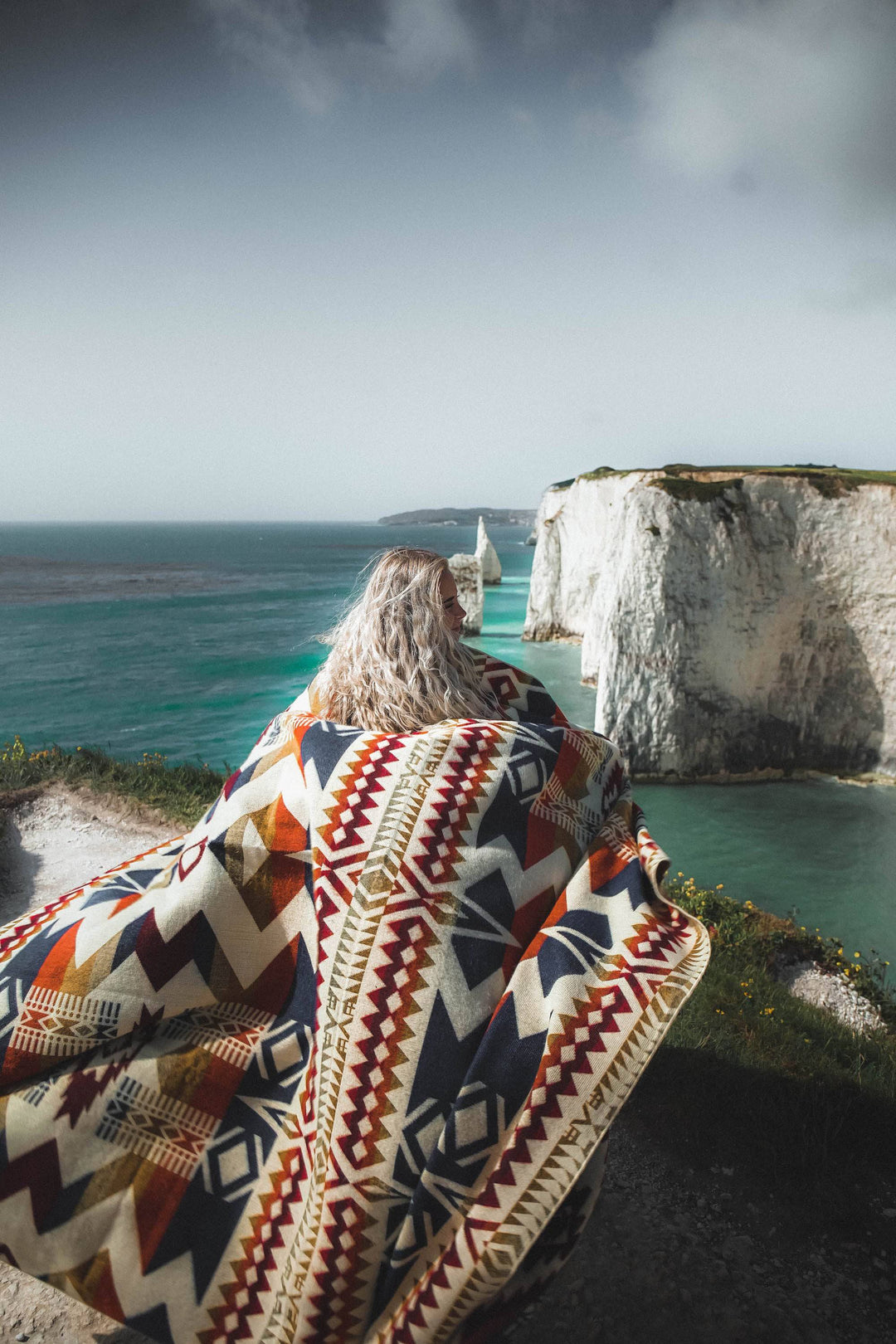 Vibrant Autumn Awa blanket showing the warm geometric weave with a bound edge.