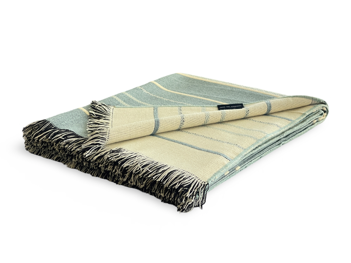 Mint and natural Equinoccio throw blanket, made in Ecuador.