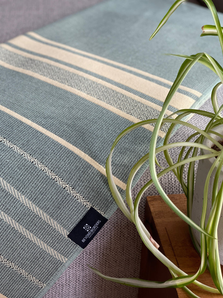 Equinoccio Mint Natural striped throw with mint-and-cream tasseled fringe.