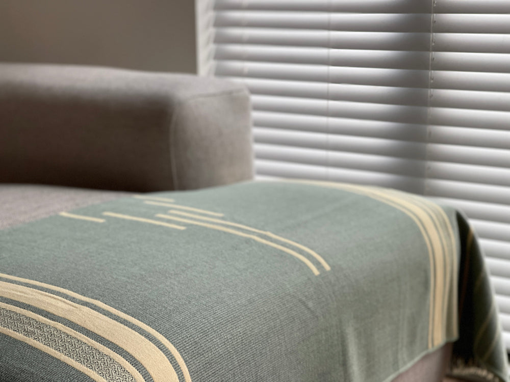 Mint Natural Andean throw blanket showing the striped weave and 2-inch fringe.