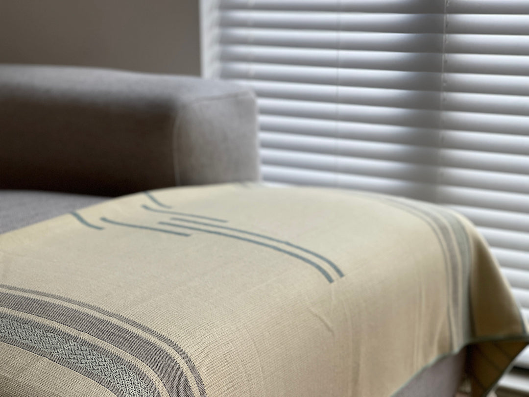 Handwoven Equinoccio Mint Natural throw in cream with mint and sage bands.
