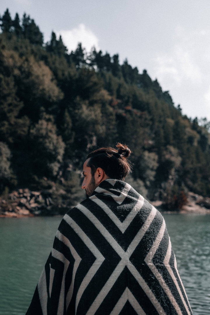 Handwoven Paramo blanket in black and cream, high-contrast concentric geometric design.