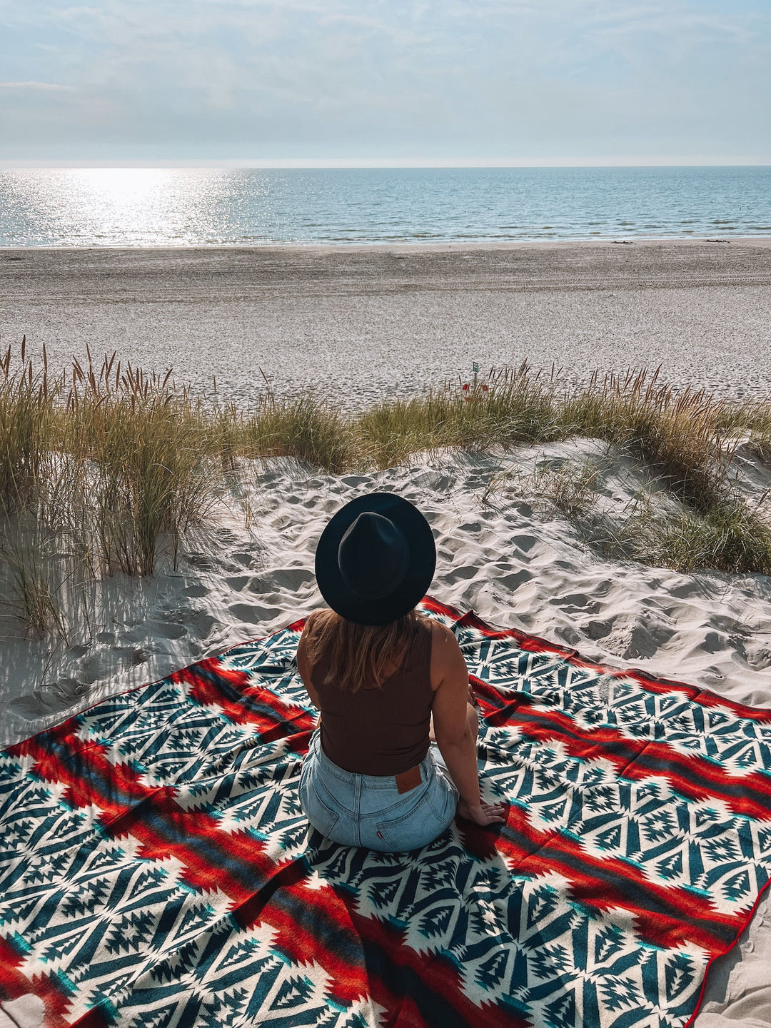 Campfire throw blanket showing navy and teal geometric pattern with rust stripes.