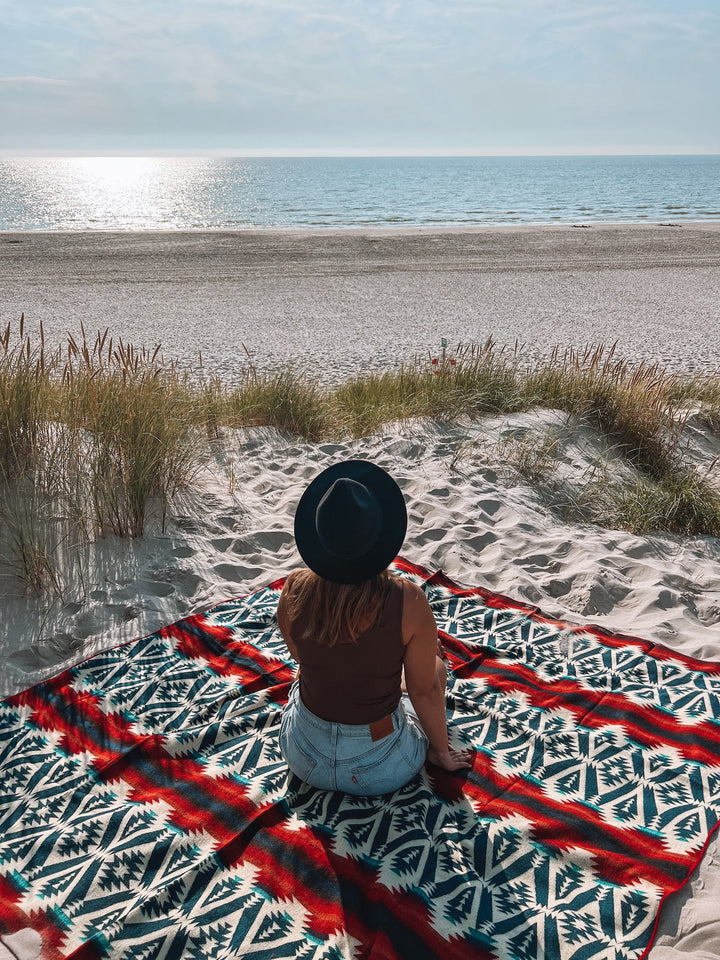 Campfire throw blanket showing navy and teal geometric pattern with rust stripes.