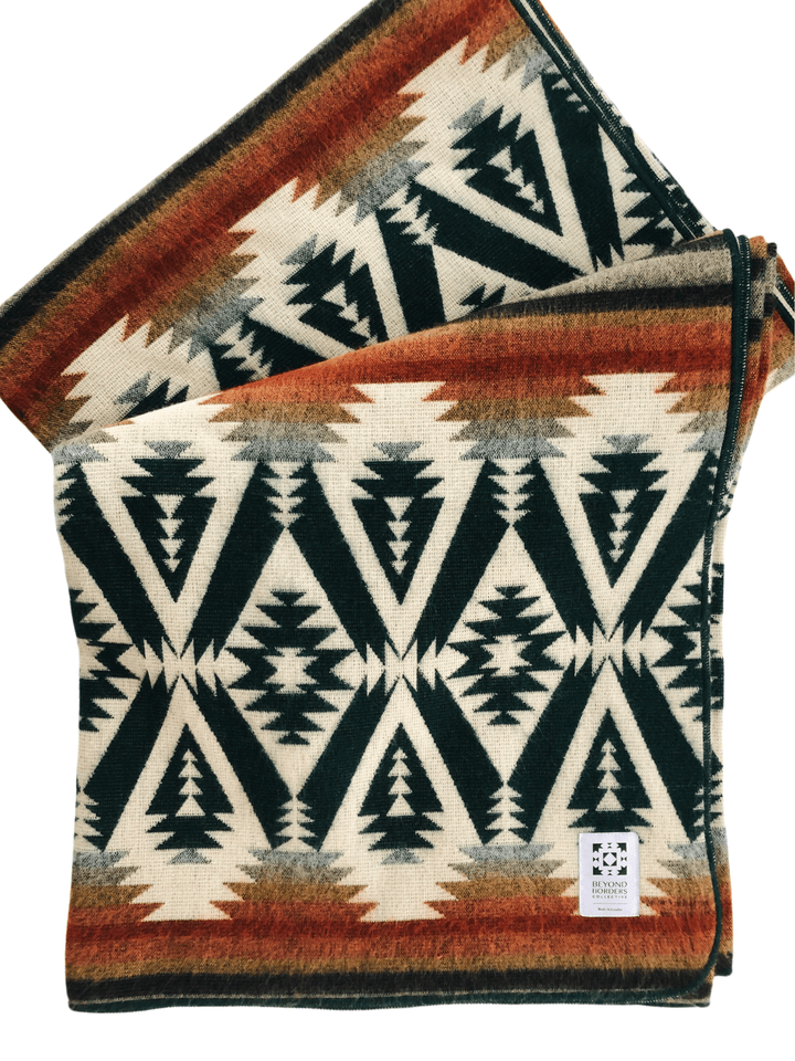 Handwoven Andean throw blanket in evergreen green with rust, mustard, and grey on cream.