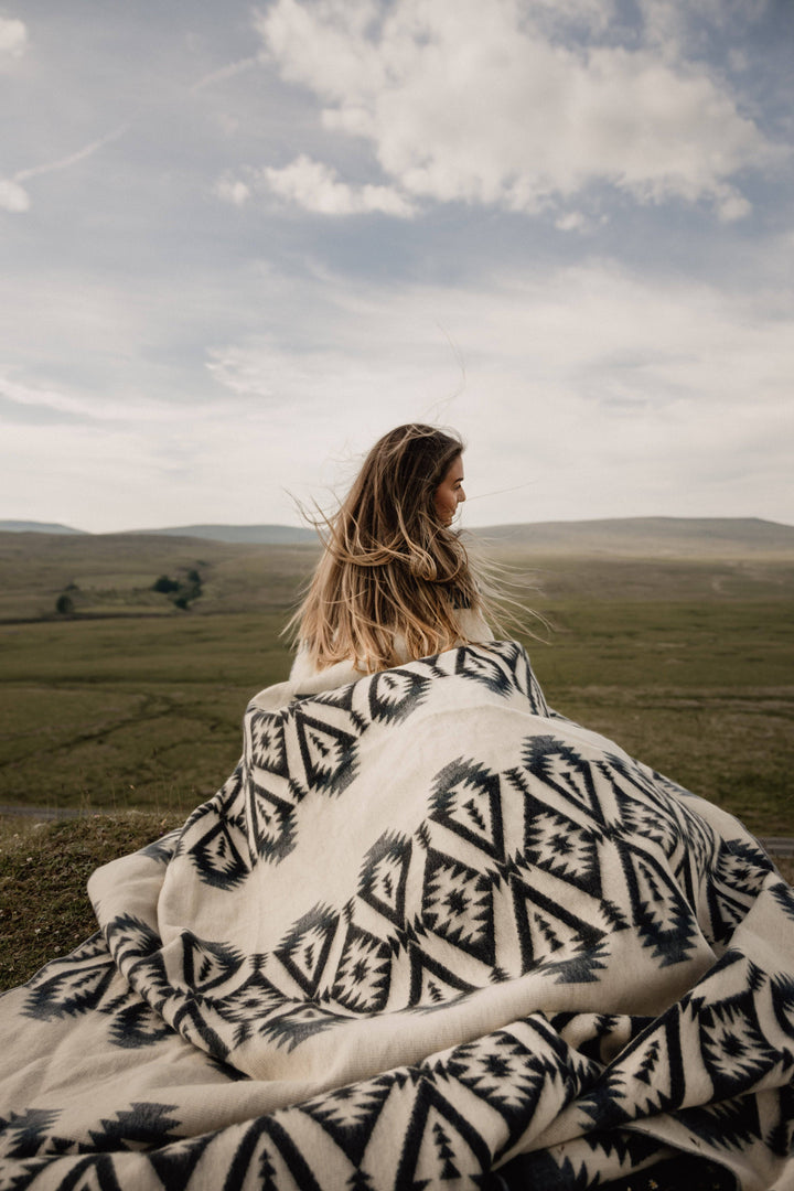 Greyscale throw blanket showing the black-on-cream diamond weave.