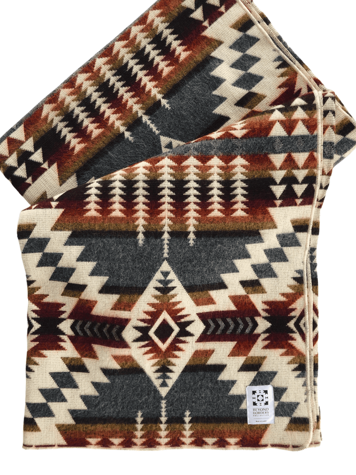 Handwoven Andean throw blanket in a warm Campfire Ash palette of cream, rust, and slate.