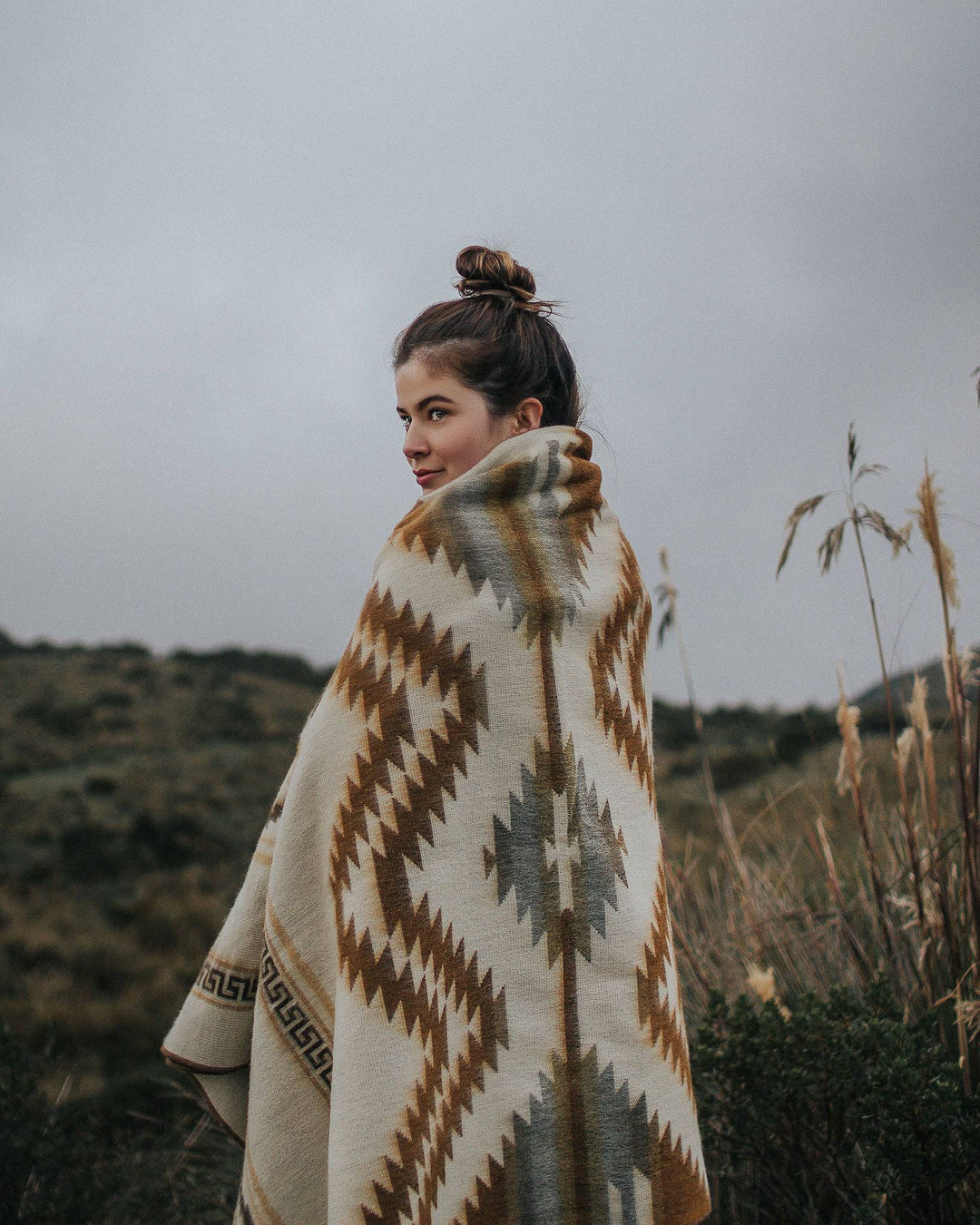 Beyond Borders Collective Shuar blanket in chocolate, tan, and cream geometric.