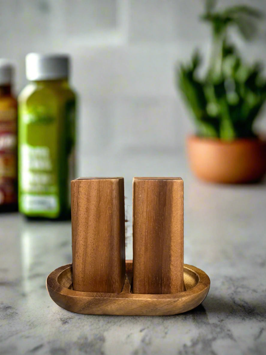 Acacia wood salt and pepper shakers with a matching base for the table.