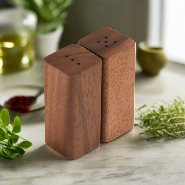 Acacia wood salt and pepper shakers with a matching base and sleek design.
