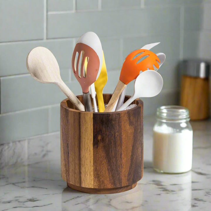 Acacia wood rotating lazy Susan utensil holder, a round wooden organizer holding utensils.