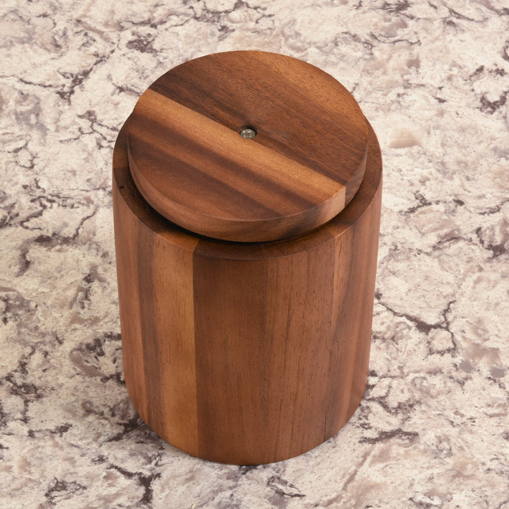 Acacia wood rotating lazy Susan utensil holder for easy-access kitchen organization.