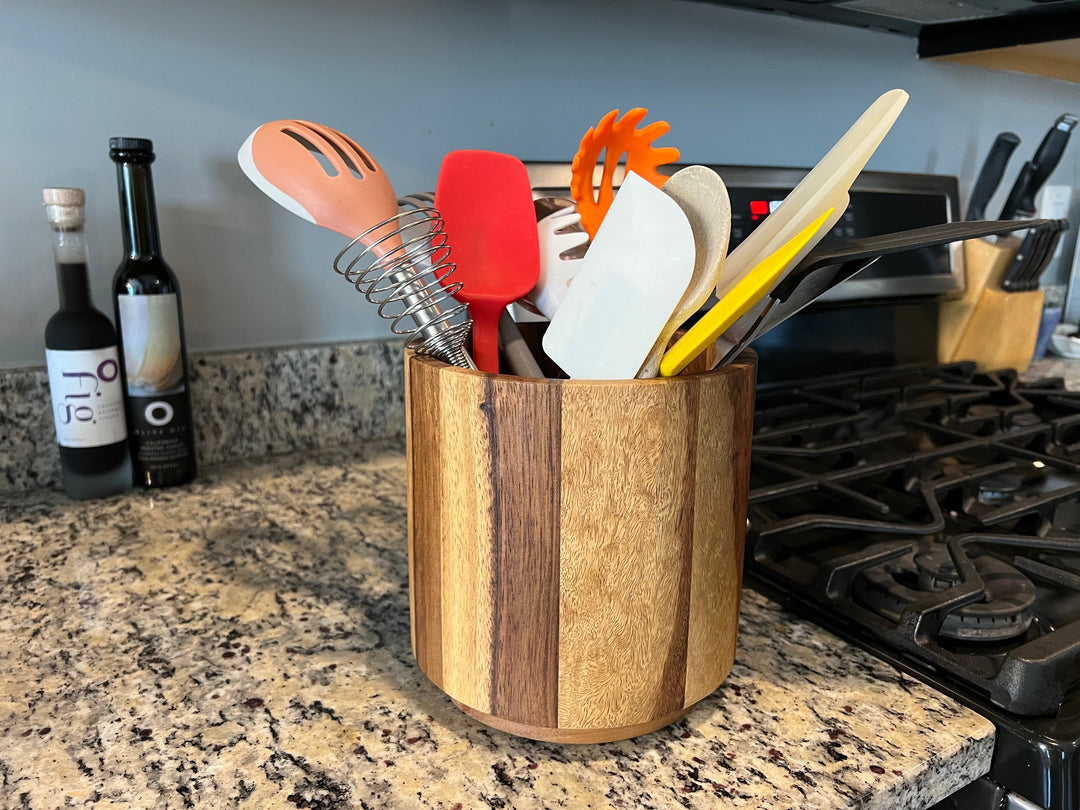 Acacia wood rotating lazy Susan utensil holder with divided compartments.