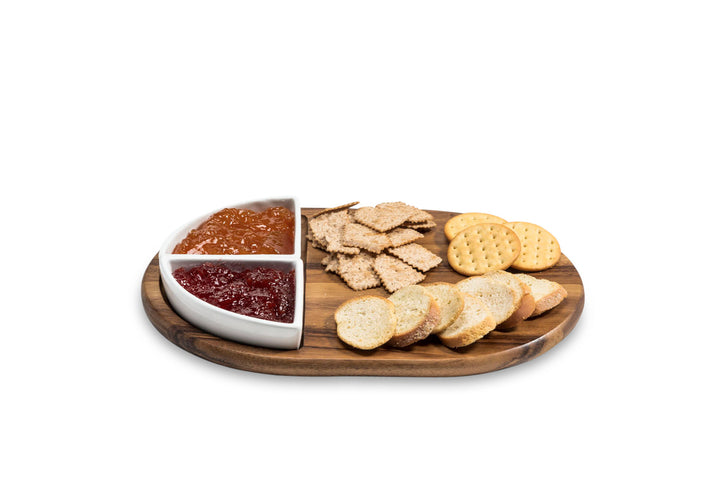 Acacia charcuterie board with two triangular ceramic bowls for serving cheese and meats.