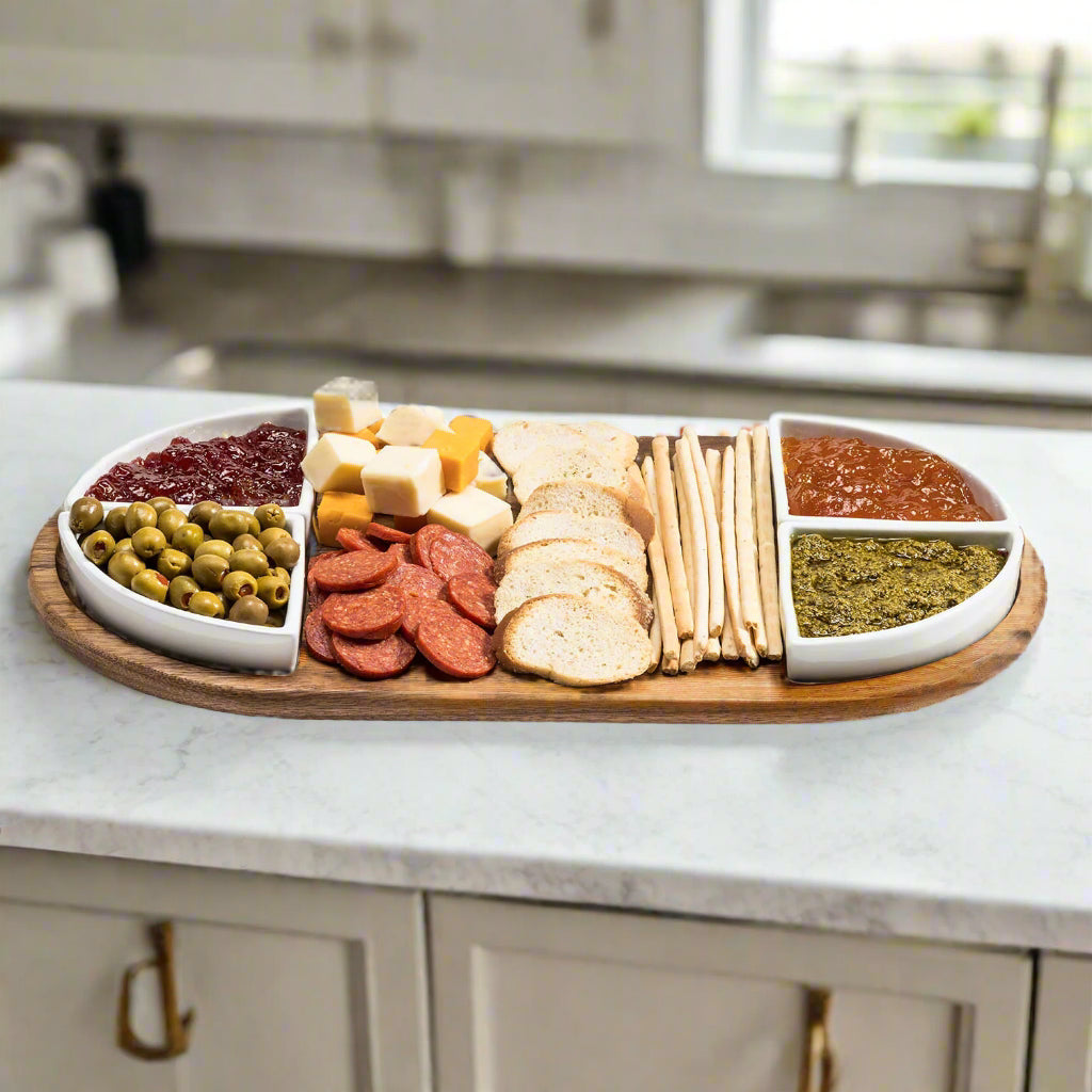 Acacia charcuterie board with four triangular ceramic bowls for serving and presentation.