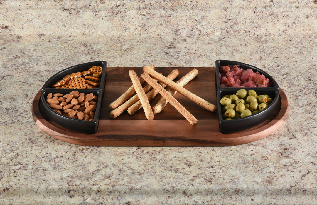 Acacia charcuterie board with four triangular ceramic bowls arranged for serving.