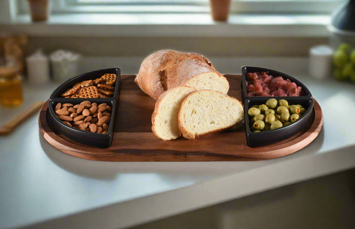 Acacia charcuterie board with four triangular ceramic bowls for snacks and appetizers.