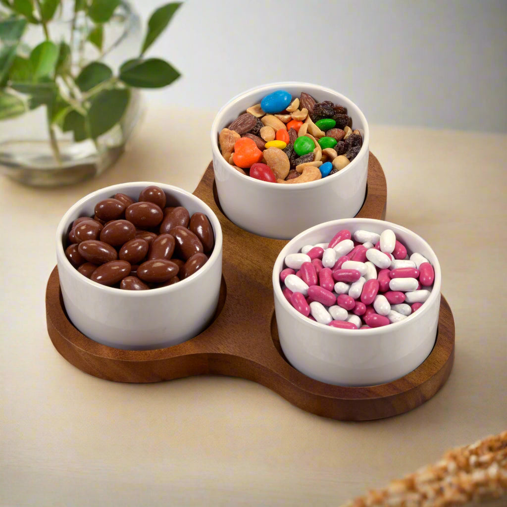 Triangular acacia server with three ceramic bowls, ideal for dips and small bites.