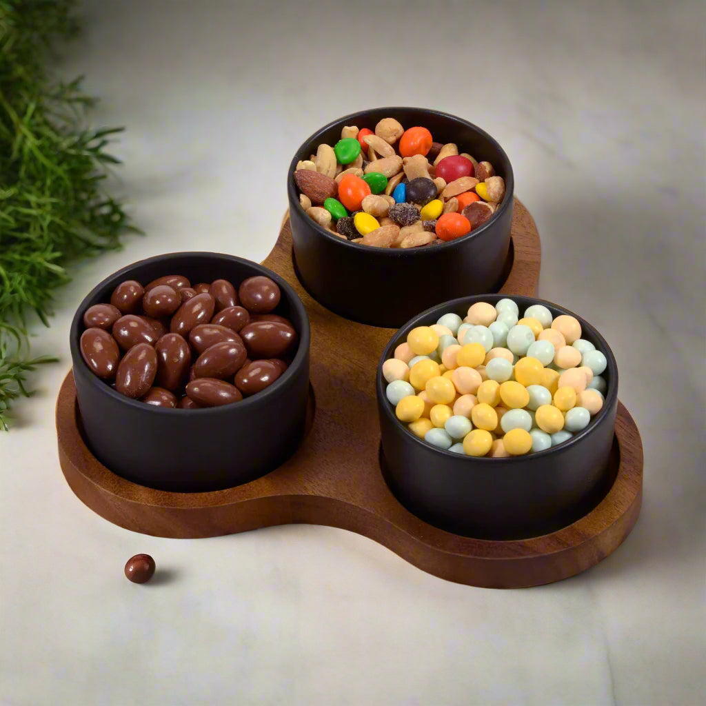Triangular acacia serving set with three ceramic bowls for stylish food presentation.
