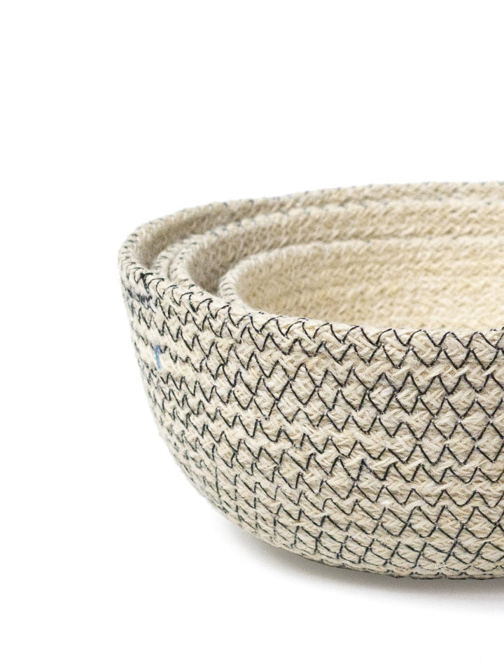 Handwoven jute storage bowls in graduated sizes, off-white with black stitching