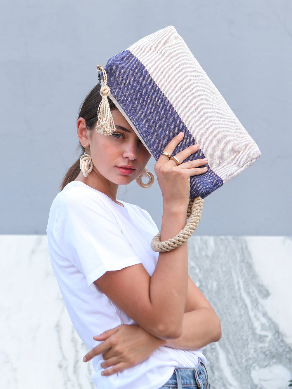 Blue and natural jute-cotton clutch with handwoven texture and tassel zipper pull