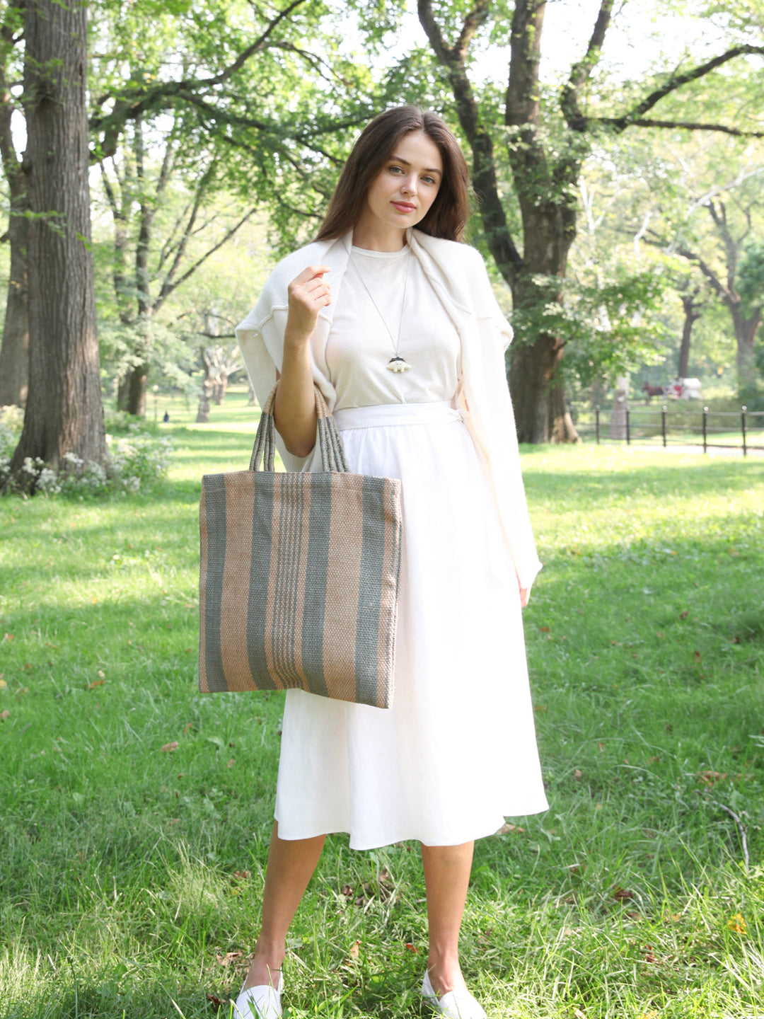Hand-loomed jute tote in soft pale-green vertical stripes on natural ground