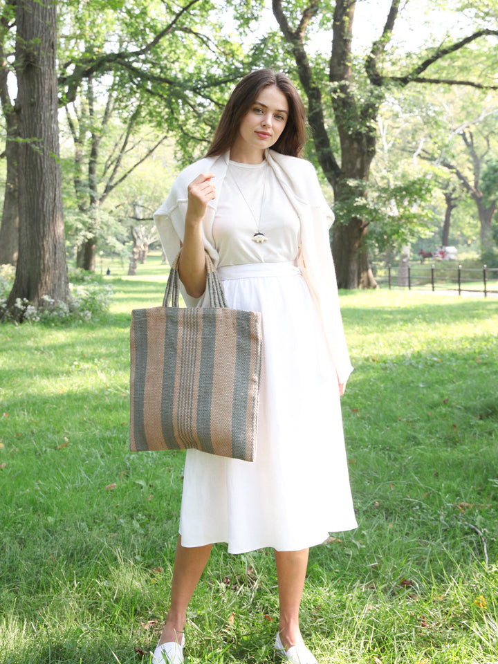 Hand-loomed jute tote in soft pale-green vertical stripes on natural ground