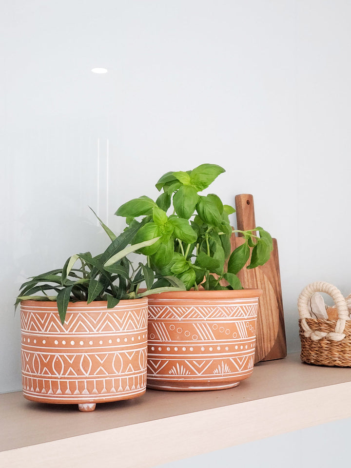 Small hand-etched terracotta pot with a carved pattern and rustic finish