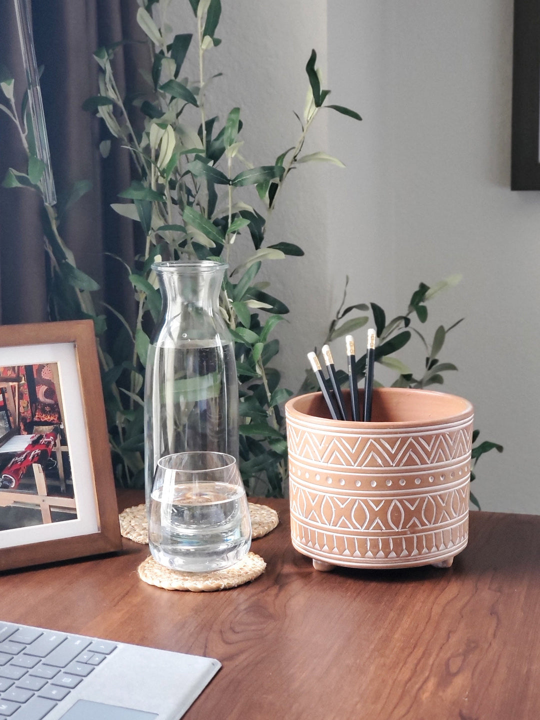 Small hand-etched terracotta pot with carved patterns on natural clay