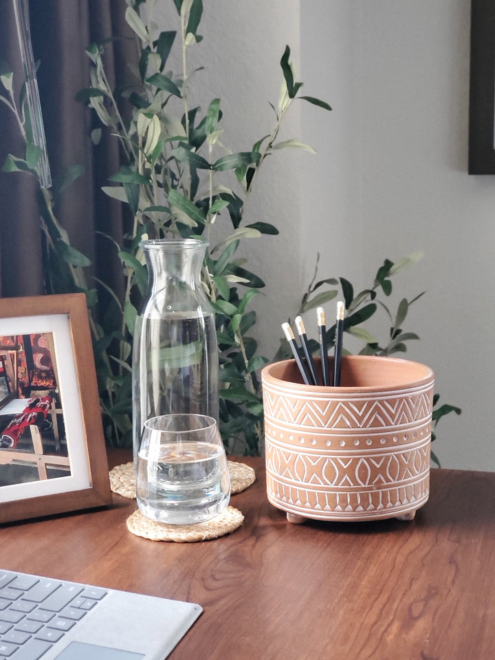 Small hand-etched terracotta pot with carved patterns on natural clay