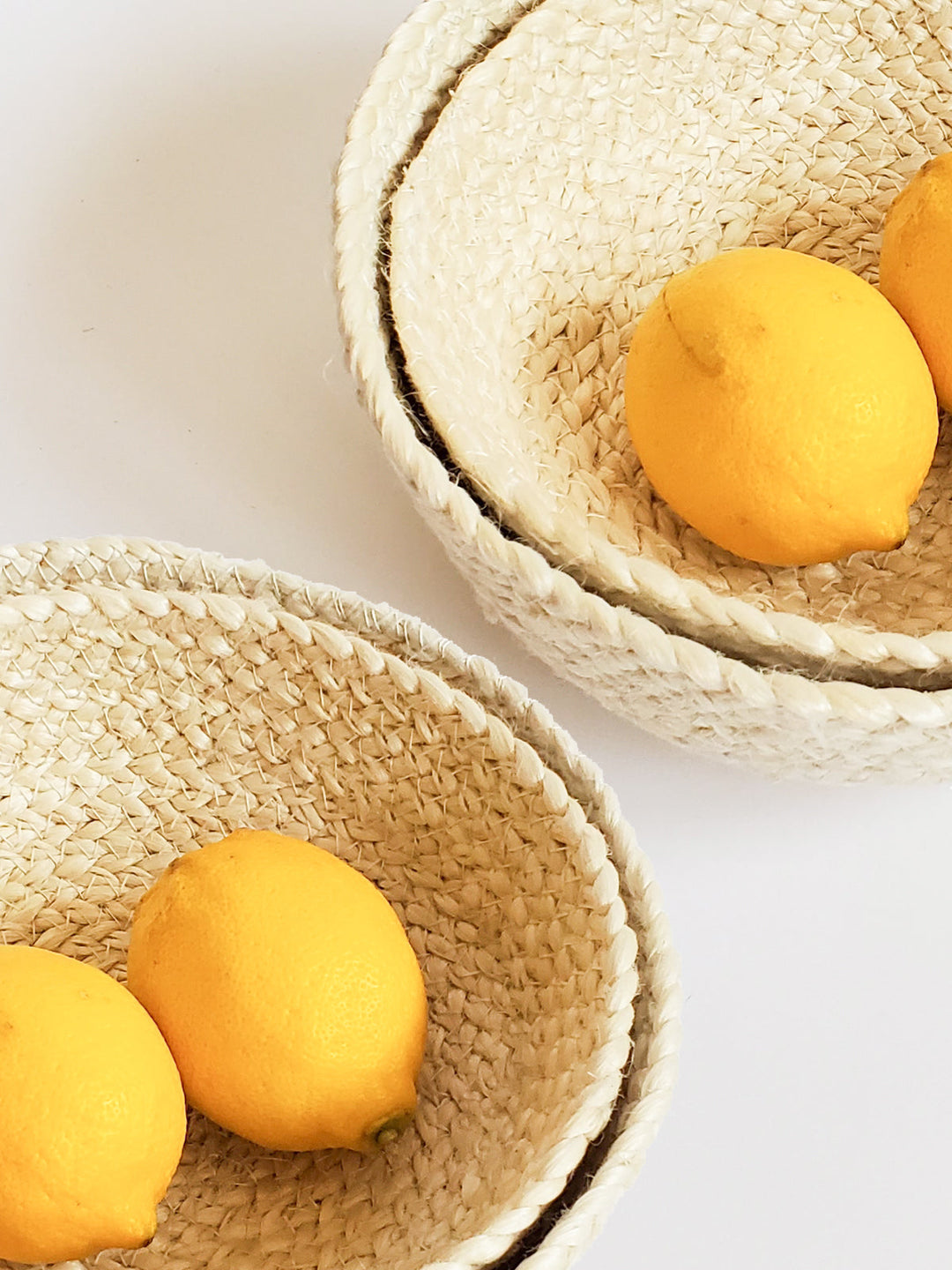 Set of four white jute storage bowls by DC-KORISSA, featuring a natural, woven design with rounded shapes and open tops.
