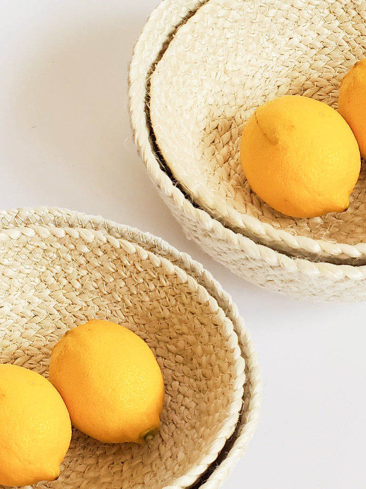 Set of four white jute storage bowls by DC-KORISSA, featuring a natural, woven design with rounded shapes and open tops.