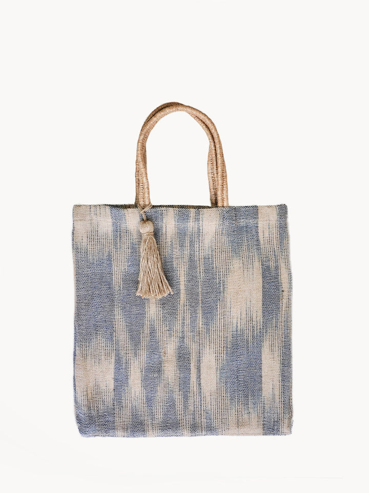 Hand-loomed jute tote with soft painterly blue vertical stripes on natural