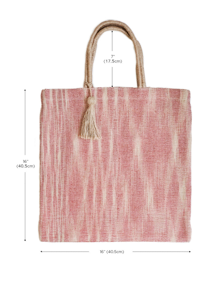 Soft red painterly jute tote with handwoven texture and tassel charm