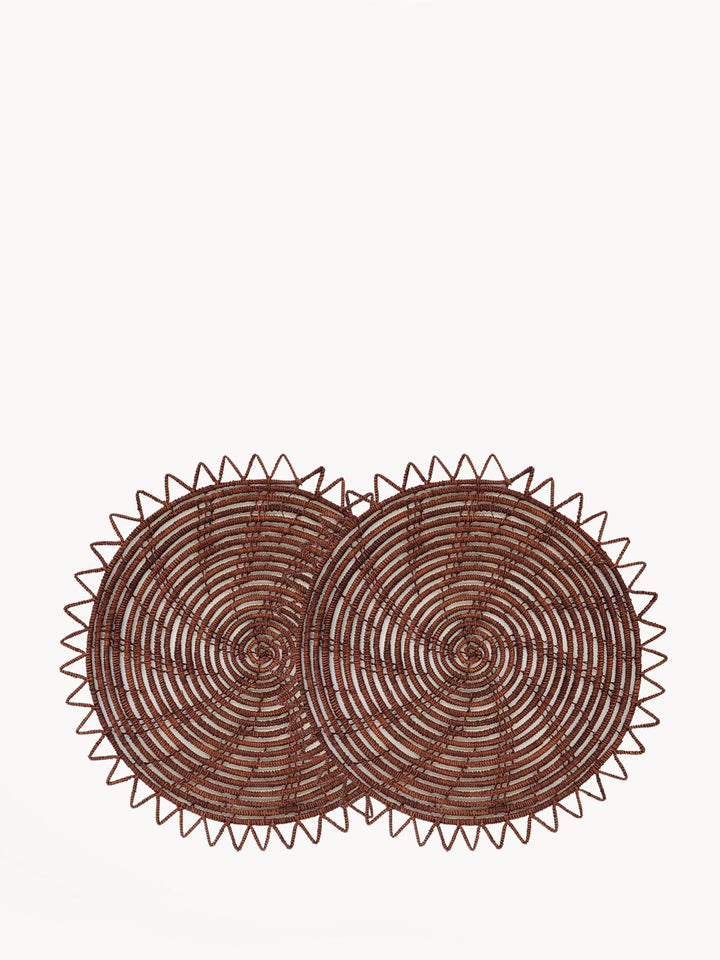 Set of 2 brown palm fiber placemats with concentric spiral weave and sawtooth border