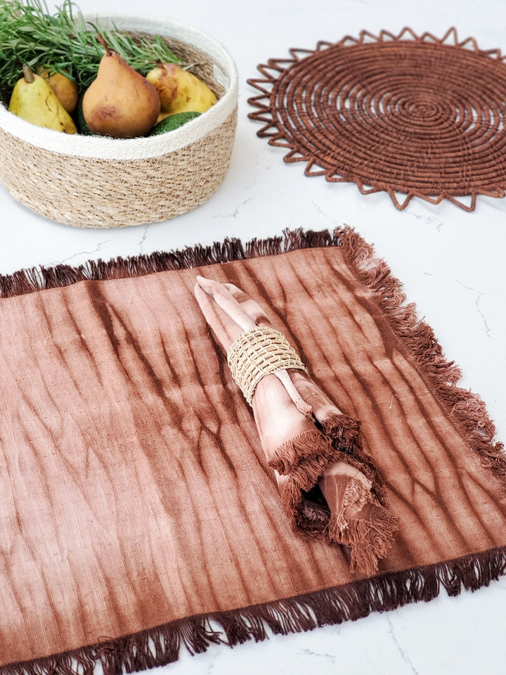 Hand-dyed shibori cotton placemats in warm earth tones with fringed edges