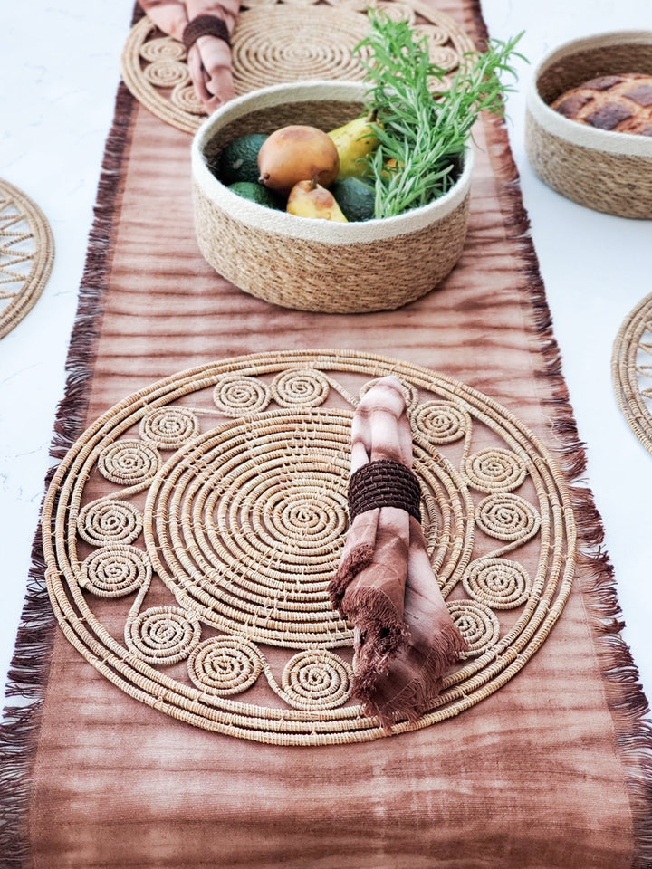 Long shibori cotton table runner in rust hues with hand-pulled dye pattern and fringed edges