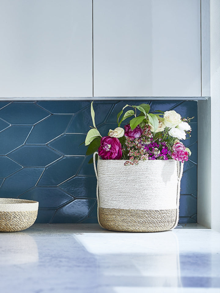 Natural fiber storage basket with side handle by DC-KORISSA, compact and versatile for organizing small items.