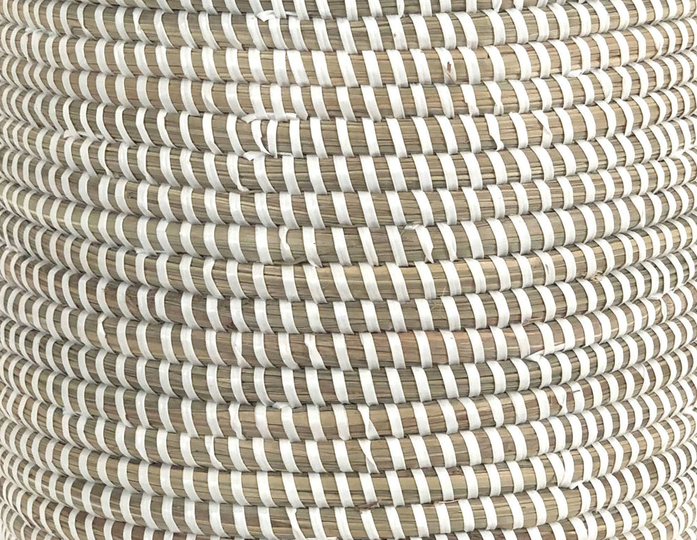White woven catch-all basket used for indoor storage and plants.