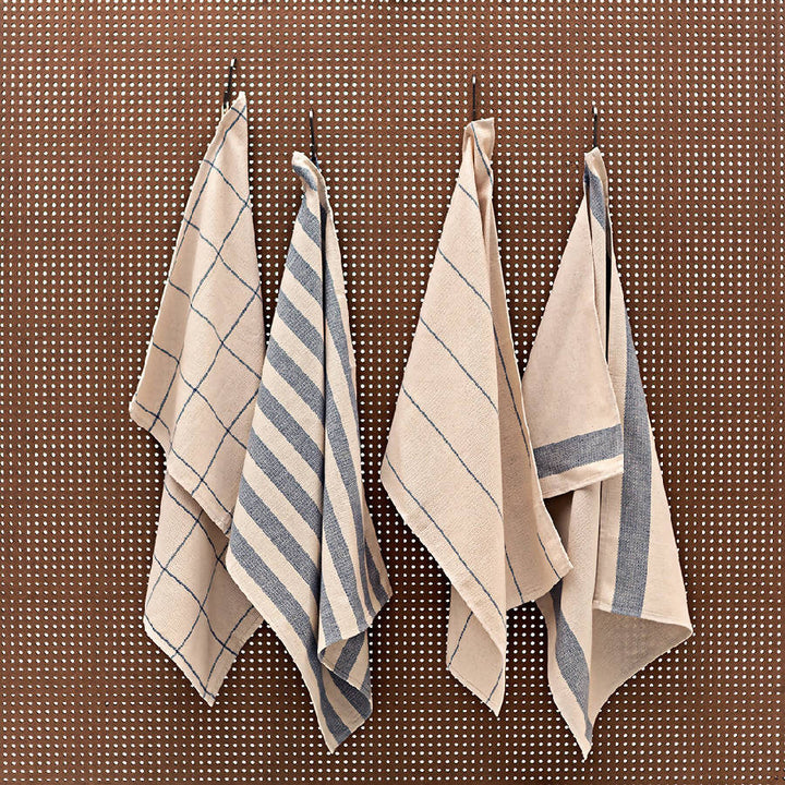 Set of four upcycled cotton kitchen towels folded, showing their minimal design.