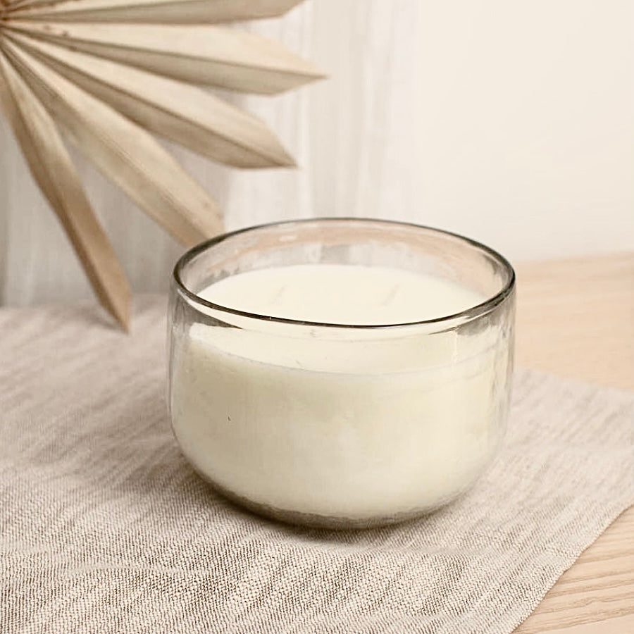 Triple-wick soy wax candle in a textured hand-blown glass bowl with a warm glow.