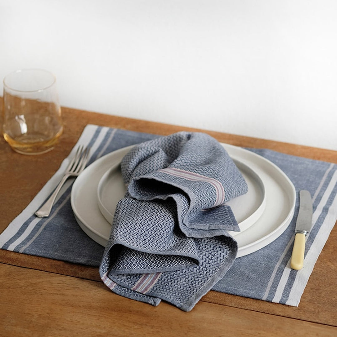 Set of four Mungo cardamom cotton dinner napkins, neatly folded.