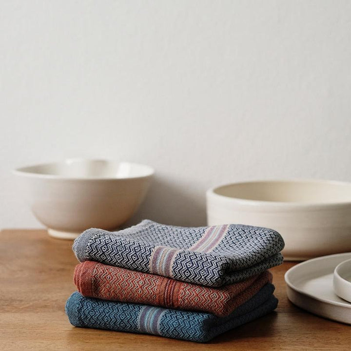 Multicolor cotton napkins showing the woven fabric in four earthy tones.