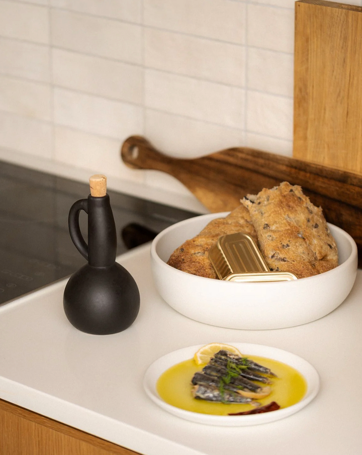 Stoneware olive oil bottle with a pour spout and handle, handcrafted in Tunisia.
